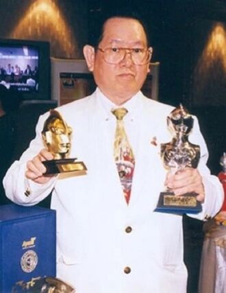 Sompote Sands holding 2 Ultraman awards