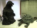 The partial First Generation Godzilla suit alongside the Kamoebas prop from Godzilla: Tokyo SOS