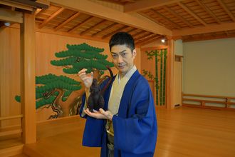 Mansai Nomura holding a Godzilla 2016 figure