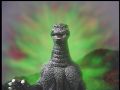 A green aura surrounds Godzilla