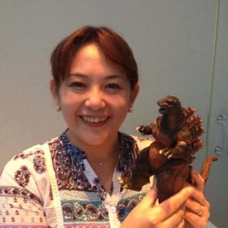 Megumi Odaka holding a figure of Burning Godzilla in 2014