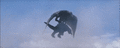 Godzilla is dropped onto the ground by Rodan