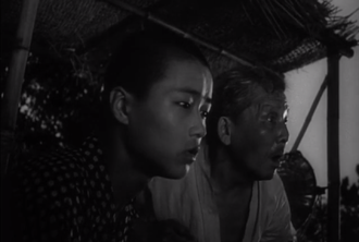 Shinkichi (at left) and an islander warn of an incoming raft in Godzilla (1954)