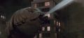 A Mothra larva spits silk at Godzilla