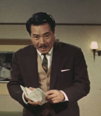 Yoshibumi Tajima as Kumayama in Mothra vs. Godzilla