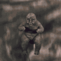 Minilla jumps down from a cliff to throw Gabara off his feet