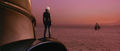 Akane stands on Kiryu's shoulder and watches Godzilla leave